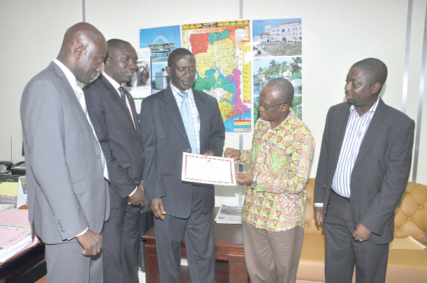 Mr Franklin  Belnye (3rd left) presenting the certificate to Mr Menson C.D Torkornoo (2nd right) at a ceremony in Accra. Those with them are Mr Godfried Osei-Boakye (2nd left), Mr Darko Yeboah (left), Legal and Human Resource Manager and Mr Isaac Obed Brown.