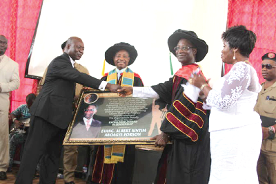 Evangelist Dr Forson (right) receiving a citation from Evangelist Paul Brako (left), an official of  Global Centre for Tranformational Leadership, while Bishop Dr Robert Arhin (middle) looks on.