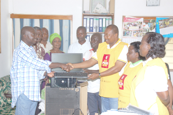 Mr Atta Akyea (left) presenting one of the computers to Dr Ekow Kaitoo, East Akyem Municipal Director of Health Services. Looking on are some NPP executives and officials of the East Akyem Municipal Health Directorate.