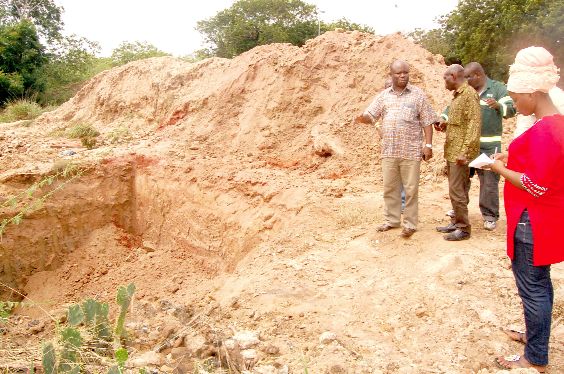 Dr Simpson Anim Boateng (left), the Director of Metro Health Department, AMA, explaining a point at the mass burial site at the Awudome Cemetery in Accra. Picture: EMMANUEL ASAMOAH ADDAI.