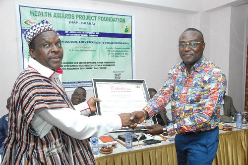Mr Alban Gbagbin,Member of Parliament for Nadoli West, presenting the award for natural health care to Dr Kwaku Frimpong, Managing Director of Champion Clinic.