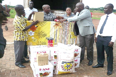  The Zonal Manager of GOIL, Mr Michael Lagble (2nd left), presenting the items to the MP for Bunkpurugu, Mr Solomon Boar, who received the items on behalf of the victims.