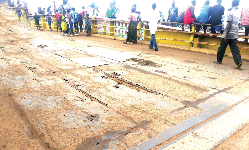 Some prospective tourists and traders walking on the dilapidated bridge