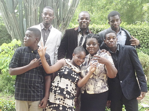 • Mr Eric Ebo Acquah (middle back row) sandwiched by his children,  Jeremiah (right) and Ezekiel (left), while on the front roll from left to right are, David, Susana Maame Sika, his wife, Angela and Frederick Acquah.