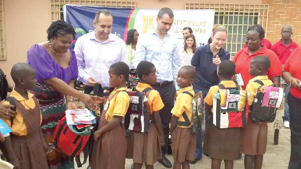 The Director of Human Resource of the Finatrade Group, Mr Elias Daher (2nd from left), presenting a schoolbag to some of the pupils in Accra yesterday. Picture: Zainabu Issah