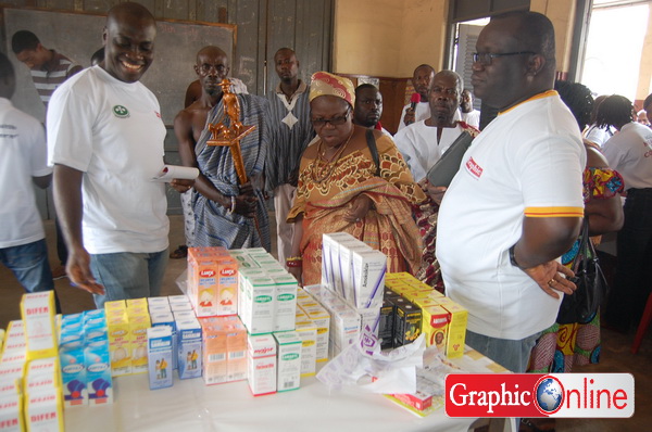 Dr. Henry Aidoo, left, and Mr kenneth Ashigbey, right and the traditional leaders examining some of the medicines offered the patients.