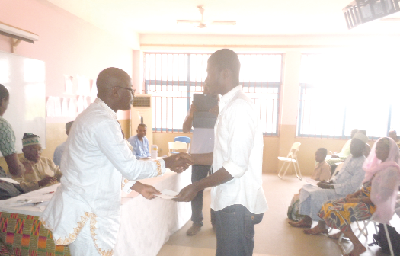  Brother Musa Amidu, President  of IDB Graduates Association presenting  a cheque to one of the beneficiaries
