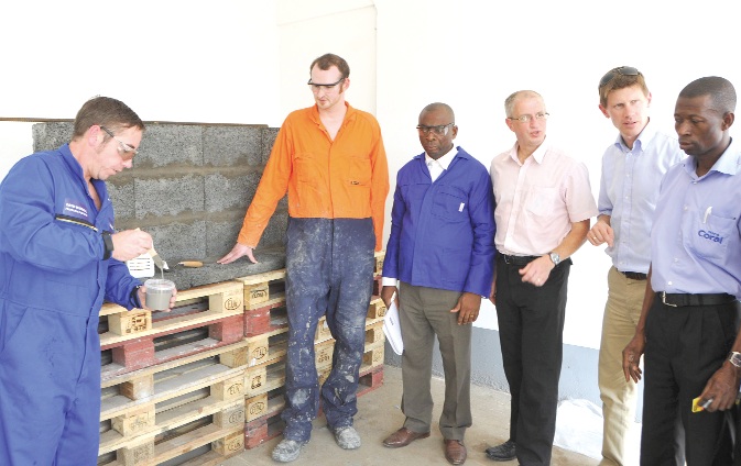 Mr Alex Sandilands (first left), concrete products specialist, demonstrating the use of the Intercrete product while Messrs David Waddle, Bonar Sarpong, Michael Harrison and Adrien Bentejac listen.
