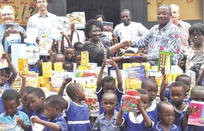 Mr Kwamena Anderson (second right), Head of Organisation and Administration of GNAT, presenting the items to Ms Elizabeth Attokora (middle), Head of  the kindergarten.        