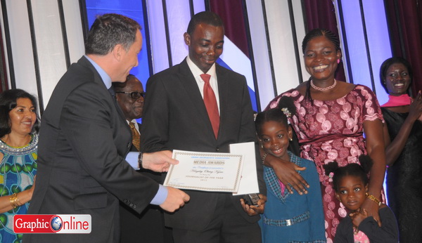 Kingsley Obeng Kyereh, supported by his wife and two daughters, is presented with his award