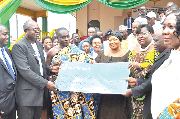 Nana Oye Luthur (arrowed), Minister of Gender, Children and Social Protection, presenting the dummy cheque covering the amount to Mr Joseph Sampson, Ashanti Regional Manager of Stanbic Bank. Picture: JOHN K. ESSEL 