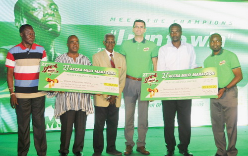Stephen Adu (in smock) of the Ghana Education Service and Danny Welbeck of the Dansoman Keep fit club together with some Nestle officials display the dummy cheque.