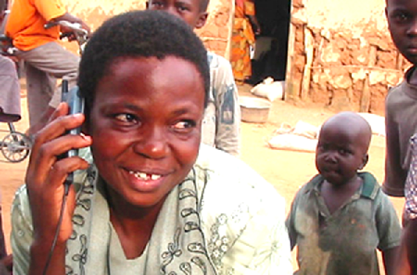 A woman in one of the MoTeCH pilot communities listening to a health message on a mobile.