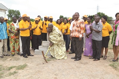 Nene Kwaku Dapo cutting the sod for the take off of the project. Looking on is  the MD of Agapet,  Mr Emmanuel Abledu (left), and the  District Coordinating Director of Ningo-Prampram Assembly, Mr Samuel Andoh–Owusu (right)  Also in the picture is the District Health Director of Ningo–Prampram District,  Mrs Gifty Ofori Ansah. (right in cloth). 