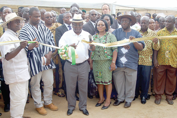Mr. Anthony Fofie, Chief executive of Ghana Cocoa Board, cutting the tape to inaugurate a new classroom block. On his left is Mr. Martin Luther Obeg, Agona East DCE. INSET: The new classroom block