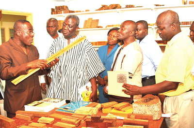 Dr Oteng Adjei (left) inspecting some research products during his visit. With him include Dr Victor Agyeman (middle), Dr Musheibu Mohammed Alpha (second left) and Dr Emmanuel Ebanyenle (right), Head of the Wood Anatomy Department. PICTURE: John K. Essel