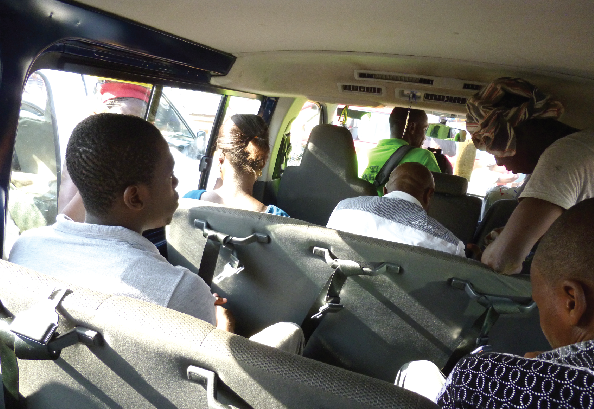 Passengers sit in a bus without wearing seatbelts.