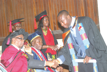   Prof. Francis Anane Joppa (seated left) congratulating Mr Godwin Amla (right) on receiving his postgraduate degree certificate. 