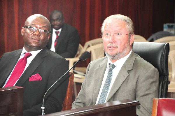 Mr Gilbert Hie (seated right), Chief Executive Officer, Societe General, answering questions at the Judgement Debt Commission sitting in Accra. With him is Nii Arday Wontumi (left), counsel for the company. Picture: SAMUEL TEI ADANO