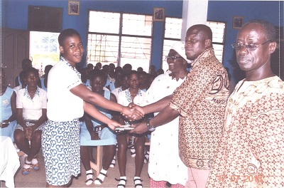 Mr Fabien Belieb (right), the Regional Grand Knight of Ashanti, presenting a set of mathematical instruments to Gloria Agyeman (left), a Form 2 General Arts student of Mary’s Girls SHS at Konongo