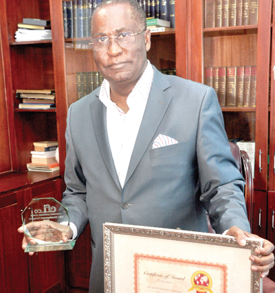 Mr Andrew Kwabena Asamoah, Executive Chairman of A & C Development Co. Ltd, which owns the A & C Shopping Mall, displaying some of his personal awards