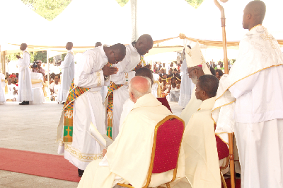 Two of the newly ordained priests bow in front of Archbishop Charles G. Palmer Buckle (arrowed) for prayers during the ordination service. Picture: Emmanuel Asamoah Addai