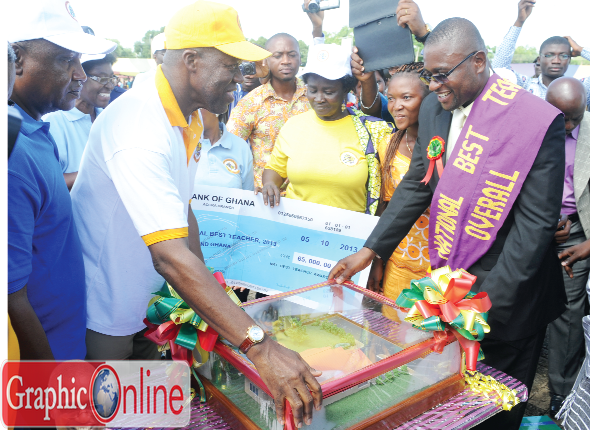 Vice-President Amissah-Arthur presenting a prototype of the three-bedroom house to Mr Simon Jude Yifaa, the National Best Teacher.