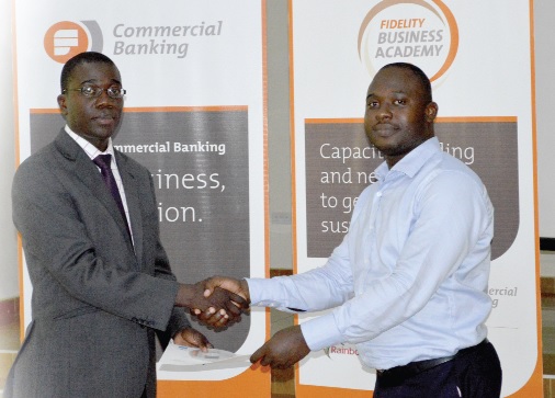 Mr Julian Opuni, Head, Commercial Banking, Fidelity Bank (left), presenting a certificate to one of the participants.
