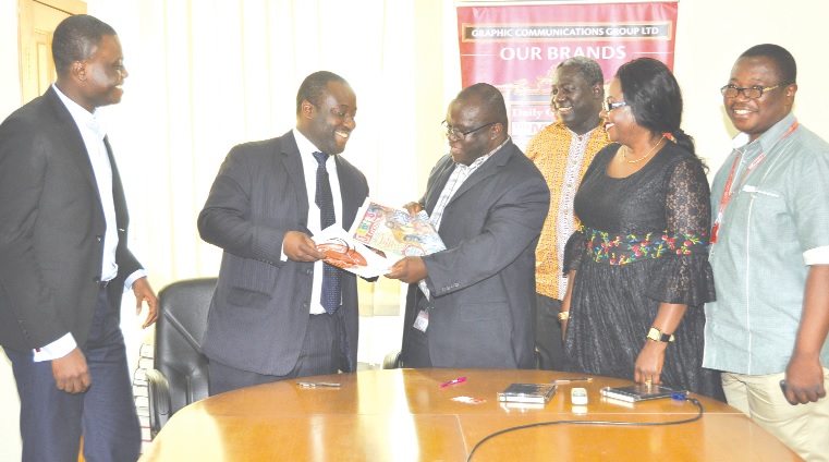 Mr Kenneth Ashigbey (3rd left) and Mr Kofi Akyea (2nd left)  exchanging the agreement document, while Mrs Mavis Kitcher (5th left), Mr Adu Dadzie (4th left), Mr Hope Adusu (right) and Mr Ato Baiden (left) look on.