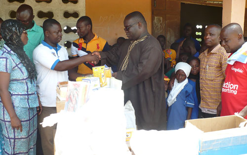 A school official (2nd left) thanking Mr Kenneth Ashigbey, MD of GCGL for the company's donation to Baz Primary School in Tamale