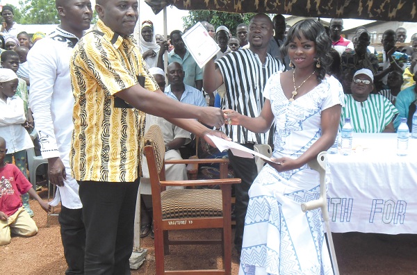Miss Ibrahim Wasila, one of the 22 newly trained dressmakers, receiving her certificate from Mr Abass Karim. 