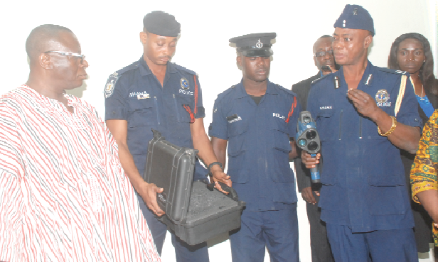 ACP Angwubutoge Awuni explaining to Alhaji Suleman Amin Amidu (in smock), the Minister of Road and Highways, how the radar gun works. With them are other police officers and staff of the National Road Safety Commission. Picture: EMMANUEL BAAH