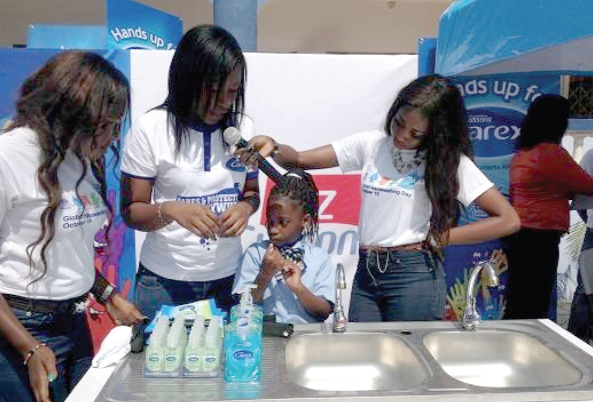 Pearl Annor (2nd left) taking a pupil through hand washing procedures
