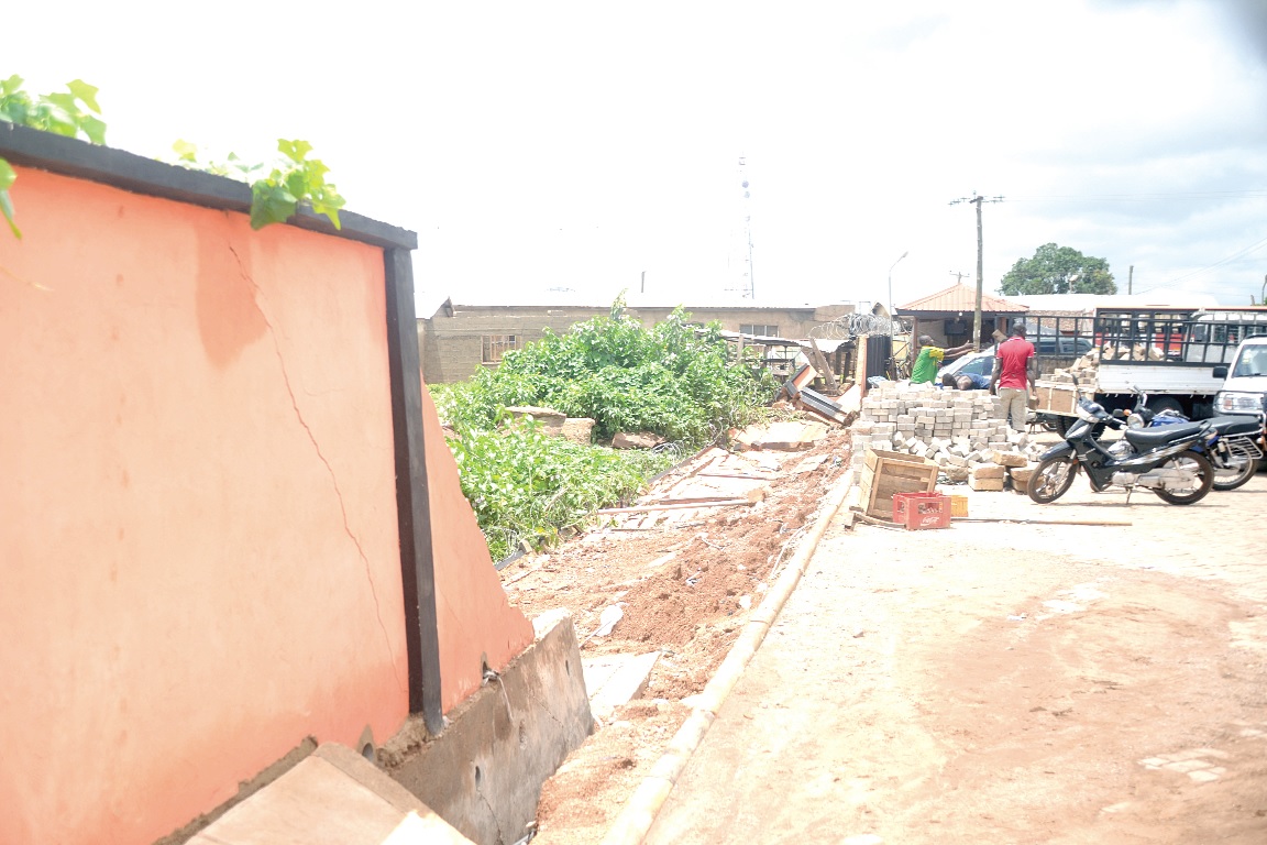 Some workers collecting the debris of a fence wall of the Metro Mass Transit station that collapsed after the heavy downpour in the Tamale Metropolis.