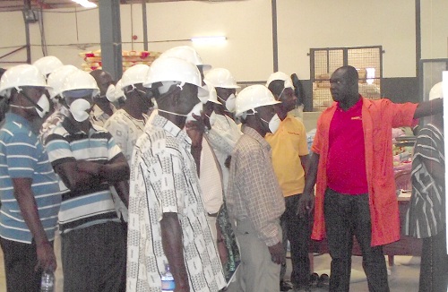 Mr Richmond Asare (right), Quality Control Manager explaining the production process to the WAG members during the visit.