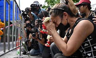 A woman prays for her deceased daughter and her son-in-law