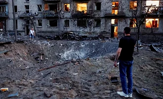Explosions formed a crater next to bombed-out buildings in Kyiv