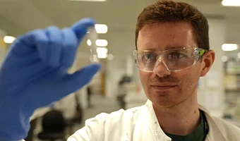Researcher Alex Sampson holds the experimental Ebola vaccine