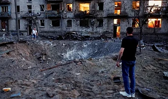 Explosions formed a crater next to bombed-out buildings in Kyiv